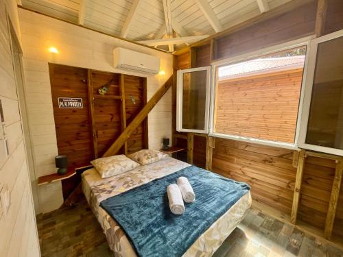 a bedroom with a bed in a wooden cabin at Bungalow cosy à Deshaies avec piscine in Deshaies