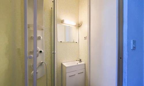 une petite salle de bain avec toilettes et miroir dans l'établissement Studio rdc mont dore centre, à Le Mont-Dore
