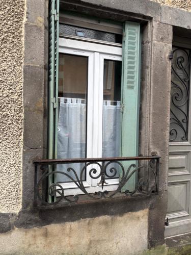 une fenêtre d'un bâtiment avec un balcon dans l'établissement Studio rdc mont dore centre, à Le Mont-Dore