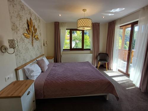 a bedroom with a bed and a desk and a window at Nobila in Sinaia