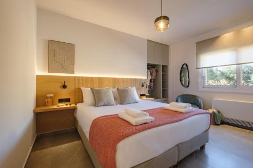 a bedroom with a large bed with towels on it at Olive Garden House in Gastourion