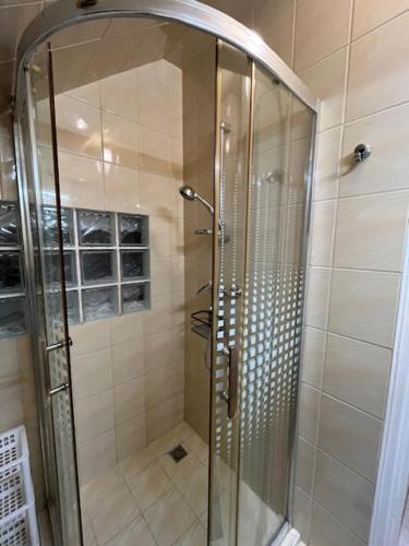 a shower with a glass door in a bathroom at Haraplak in Hajdúszoboszló