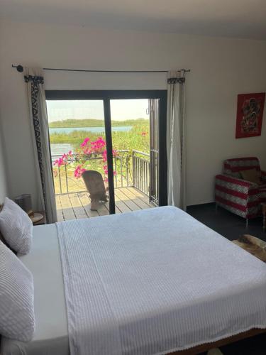 a bedroom with a bed and a view of a balcony at Villa Chez Diarra in Saint-Louis