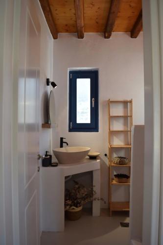 a white bathroom with a sink and a window at Isla Catalina in Apollonia