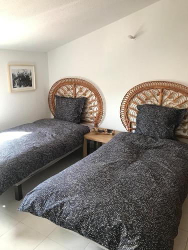 deux lits côte à côte dans une chambre dans l'établissement Maison à la mer, à Sainte-Marie-la-Mer