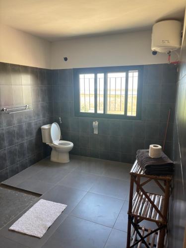 a bathroom with a toilet and a window in it at Villa Chez Diarra in Saint-Louis