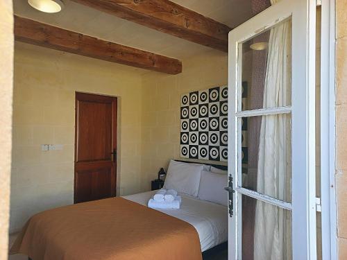 a bedroom with a bed and a sliding glass door at Virginia Farmhouse in Kerċem