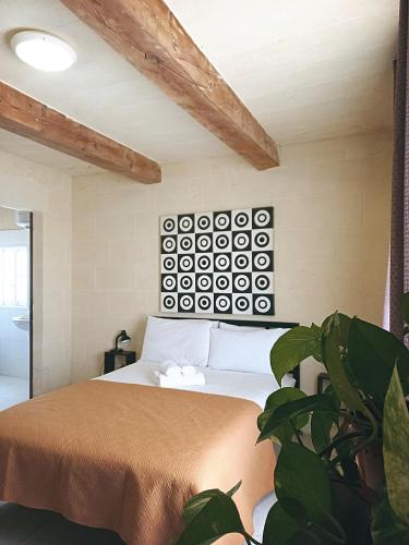 a bedroom with a bed and a plant at Virginia Farmhouse in Kerċem
