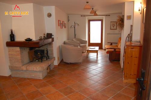 Una sala de estar con chimenea y un sofá. en Al campo base, en Civitella Alfedena