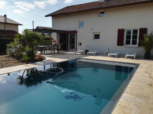 une piscine devant une maison dans l'établissement Maison basco landaise à 10 kms des plages, à Saint-Vincent-de-Tyrosse