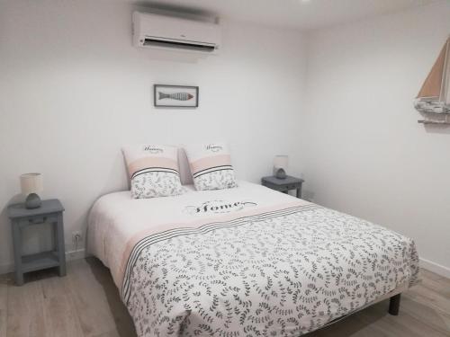 une chambre avec un lit et deux tables de nuit dans l'établissement Maison basco landaise à 10 kms des plages, à Saint-Vincent-de-Tyrosse