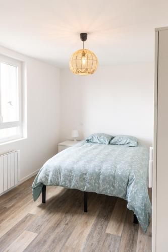 - une chambre blanche avec un lit et un lustre dans l'établissement Les chambres d'Arnaud - appartement partagé de 3 chambres, à Toulouse