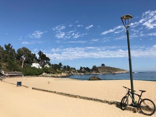 a bike parked next to a light pole on a beach at Lofts - Casa El Pangue, Zapallar in Zapallar