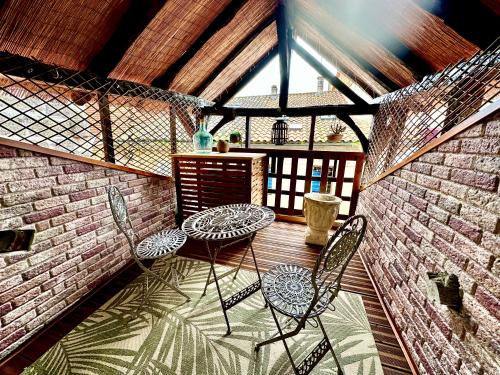 d'une terrasse avec 2 chaises, une table et un mur en briques. dans l'établissement Le Colombier de Cyrano et Roxane, à Bergerac