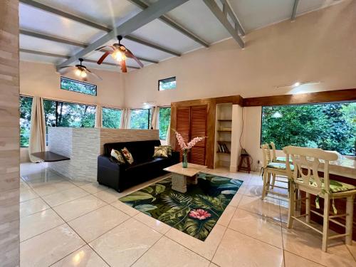 a living room with a couch and a table at Zen Zaru Free MA park tour & breakfast in Quepos