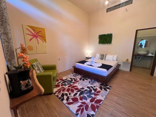 a bedroom with a bed and a chair and a rug at Zen Zaru Free MA park tour & breakfast in Quepos