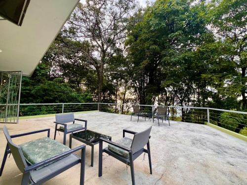 a patio with chairs and tables on a balcony at Zen Zaru Free MA park tour & breakfast in Quepos