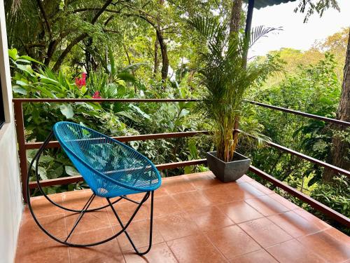 a blue chair sitting on a balcony with a plant at Zen Zaru Free MA park tour & breakfast in Quepos