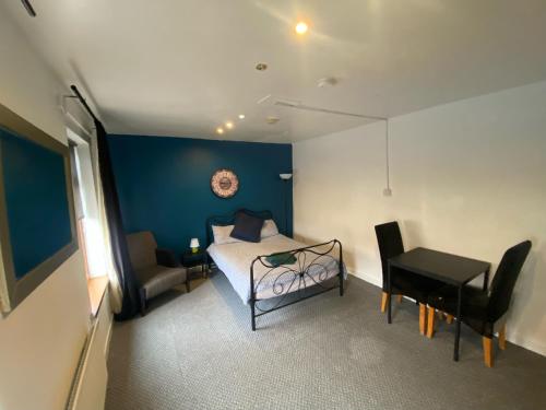 a bedroom with a bed and a table and a desk at bnb81 STRICTLY OVER 25 ONLY in Belfast