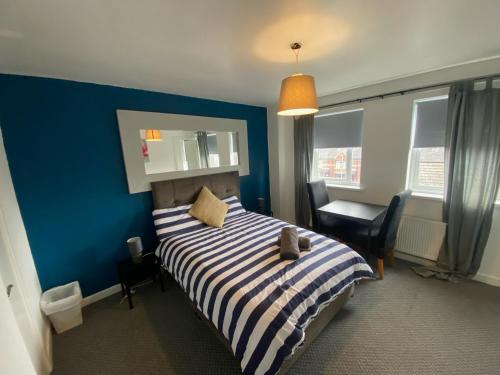 a bedroom with a bed with a blue wall at bnb81 STRICTLY OVER 25 ONLY in Belfast