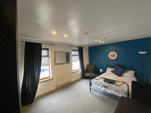 a bedroom with a bed and a blue wall at bnb81 STRICTLY OVER 25 ONLY in Belfast