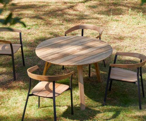 une table en bois et deux chaises autour d'une table en bois dans l'établissement Arbousiers, à Vendays-Montalivet