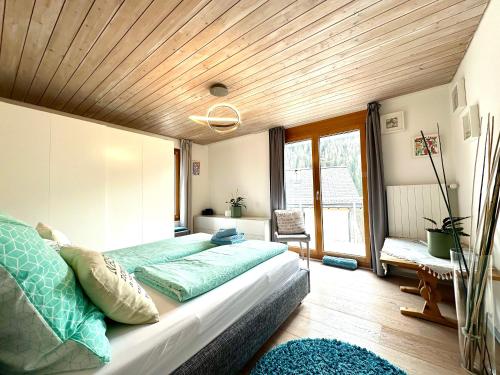 a bedroom with a large bed with a wooden ceiling at Apartment Blick Schloss Tarasp - Arventraum mit Gartenspa in Scuol