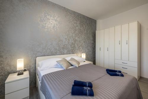 a bedroom with a large bed with two blue bags on it at Perla No1 in Kaštela