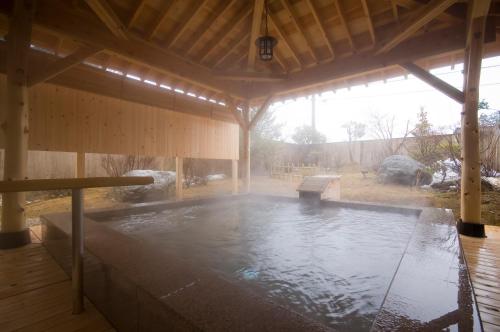 a large wooden pavilion with a hot tub in it at Tsurugi Koizuki in Kamiichi