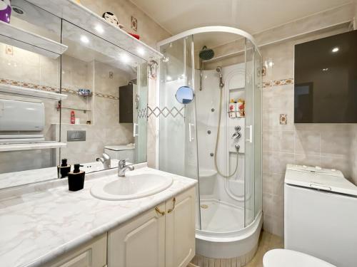 une salle de bain blanche avec une douche et un lavabo dans l'établissement Studio Front de mer, à Antibes