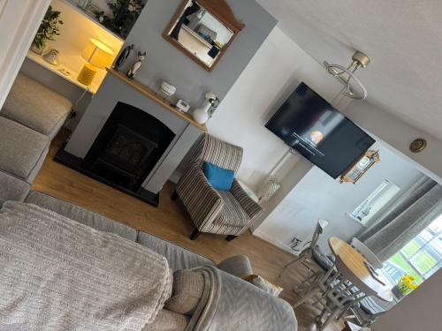 an overhead view of a living room with a fireplace and a television at Cosy Seaside Cottage in Allonby