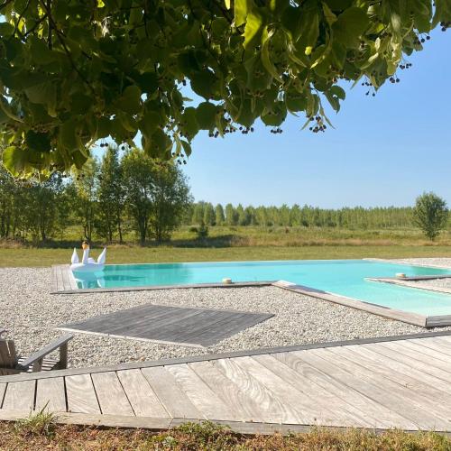 une personne assise dans une chaise à côté d'une piscine dans l'établissement Grand gîte avec piscine MAISON PORT VALADE, à Tabanac