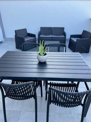 a wooden table with chairs and a plant on it at Attico sulla Riserva in San Benedetto del Tronto