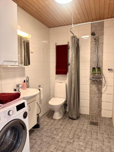 a bathroom with a toilet and a washing machine in it at Villa Centralen in Helsinki
