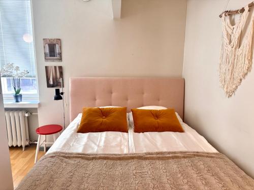 a bedroom with a bed with two orange pillows at Villa Centralen in Helsinki