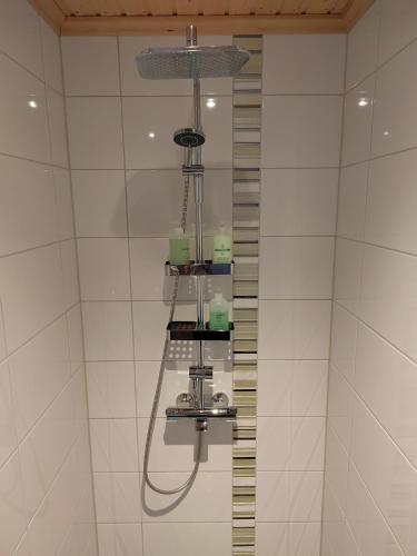 a shower in a bathroom with a shower head at Mummon Mökki in Lokka