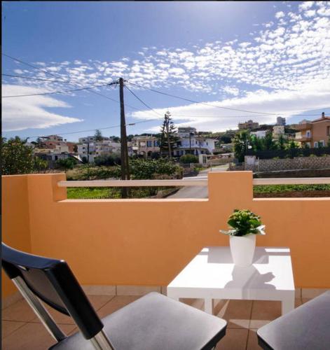 a table and two chairs and a vase with a plant at Sofoklis Apts in Stalos