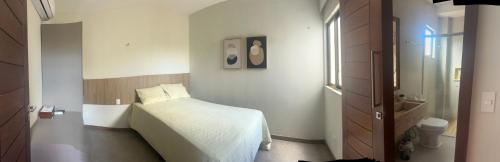 a small bedroom with a bed and a window at Casa Alegria in São-José-do-Ribamar