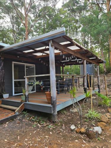 Casa con terraza de madera con techo en Settlers Cabin, en Pemberton