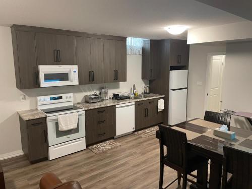 a kitchen with white appliances and a table with chairs at Modern, well-equipped, and centrally located in Fonthill