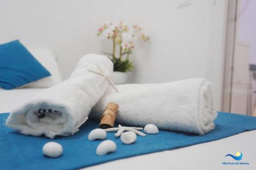 a bed with a towel and some white eggs on a blue towel at VILLA PERLA del SALENTO con piscina in Lido Marini