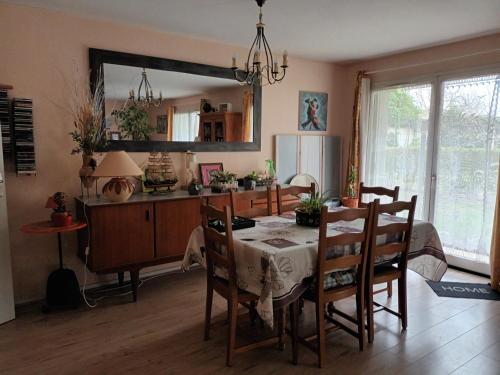 une cuisine et une salle à manger avec une table et des chaises dans l'établissement grand appartement en résidence, à Vendôme
