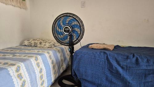 a room with a fan next to a bed at Casa Margarida in Brasília