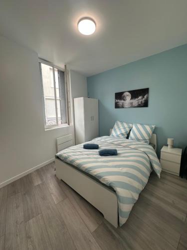 une chambre avec un grand lit aux murs bleus dans l'établissement Lune Argentée - RDC - Centre ville, à Clermont-Ferrand