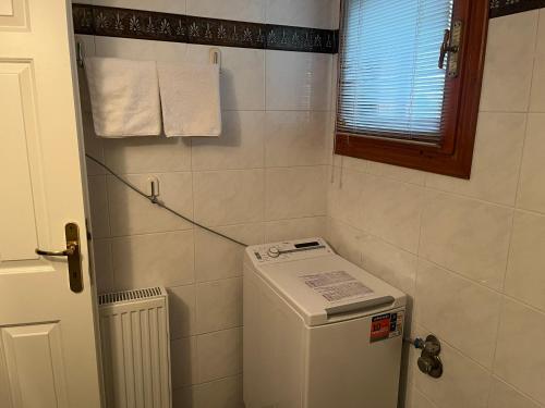 a small bathroom with a washing machine and a window at Vacation Ηouse in Nea Plagia of Halkidiki, Greece in Nea Plagia