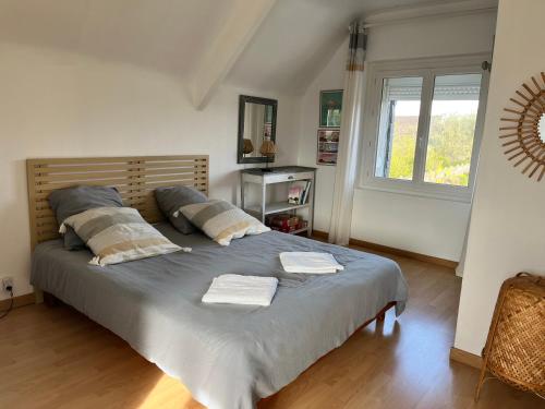 ein Schlafzimmer mit einem großen Bett mit zwei Handtüchern darauf in der Unterkunft Maison rénovée à Agon-coutainville proche de la mer, classé meublé de tourisme 3 étoiles in Agon Coutainville