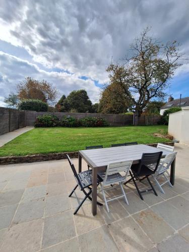 a picnic table and chairs on a patio at Gite Ker Maria Gite Ker Louis Piscine in Saint-Gravé