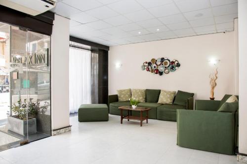 a lobby with a green couch and a table at Relax Inn Hotel in St. Paul's Bay