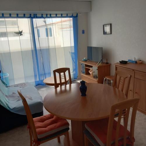 une pièce avec une table, des chaises et un lit dans l'établissement appartement saint hilaire de riez 85270, à Saint-Hilaire-de-Riez