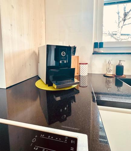 a coffee maker sitting on a counter in a kitchen at Chasa Stefania, modernes Engadiner Haus mit Wellness und Sauna in Scuol